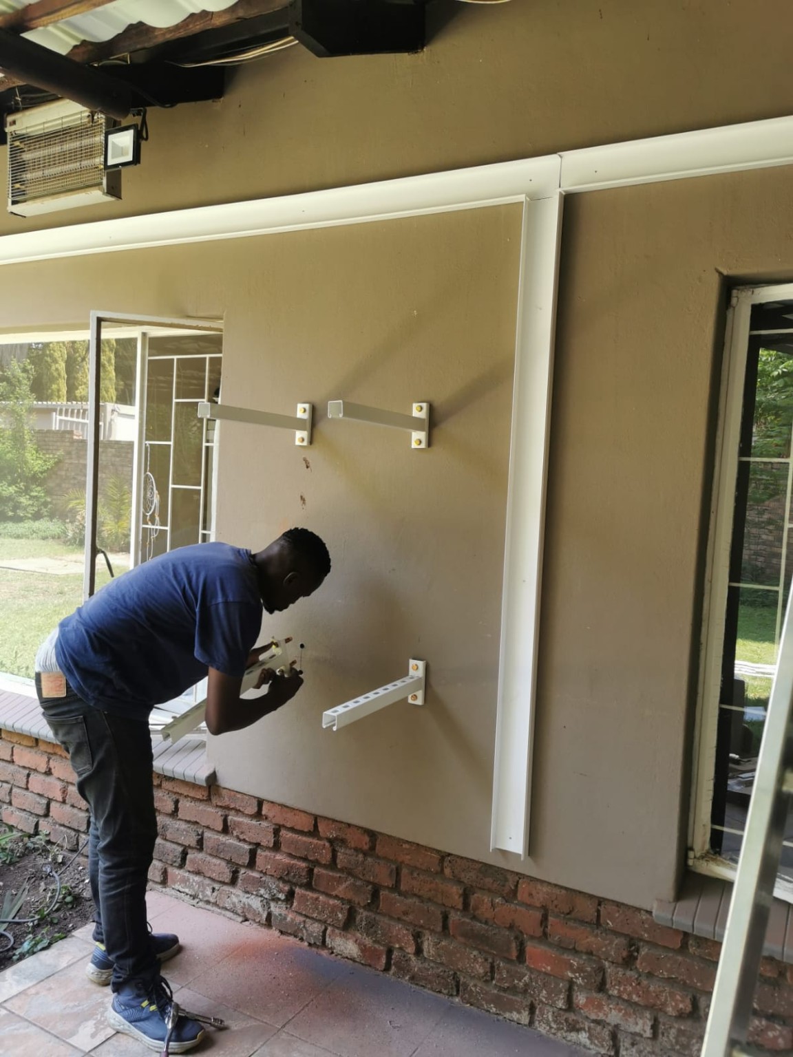 Technician working on air conditioning installation brackets